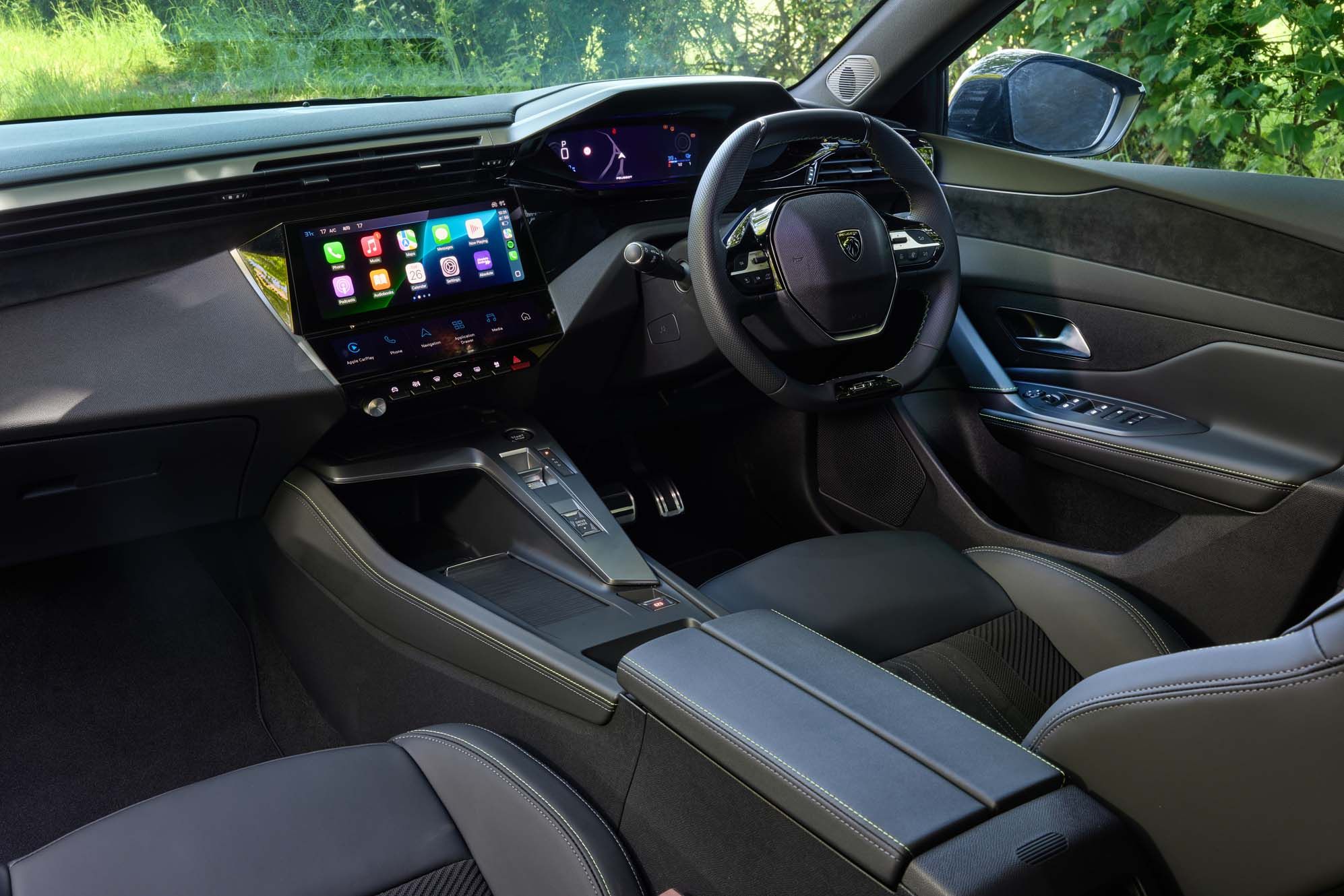 Peugeot E-308 interior featuring a sleek dashboard with a digital display, multifunction steering wheel, black upholstery, and a central touchscreen.