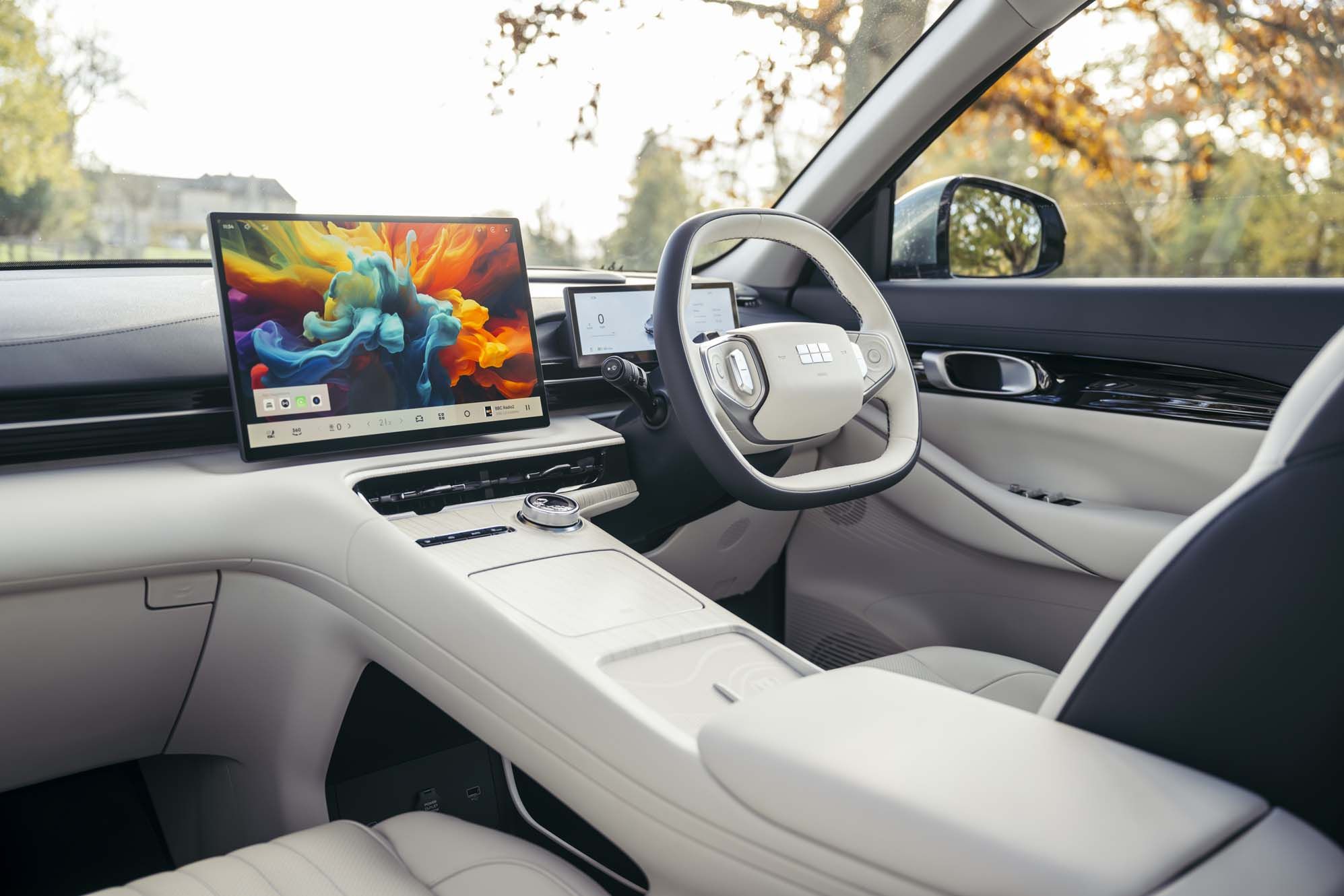 Geely EX5 interior with a large touchscreen display, sleek steering wheel, and luxurious beige leather seats.