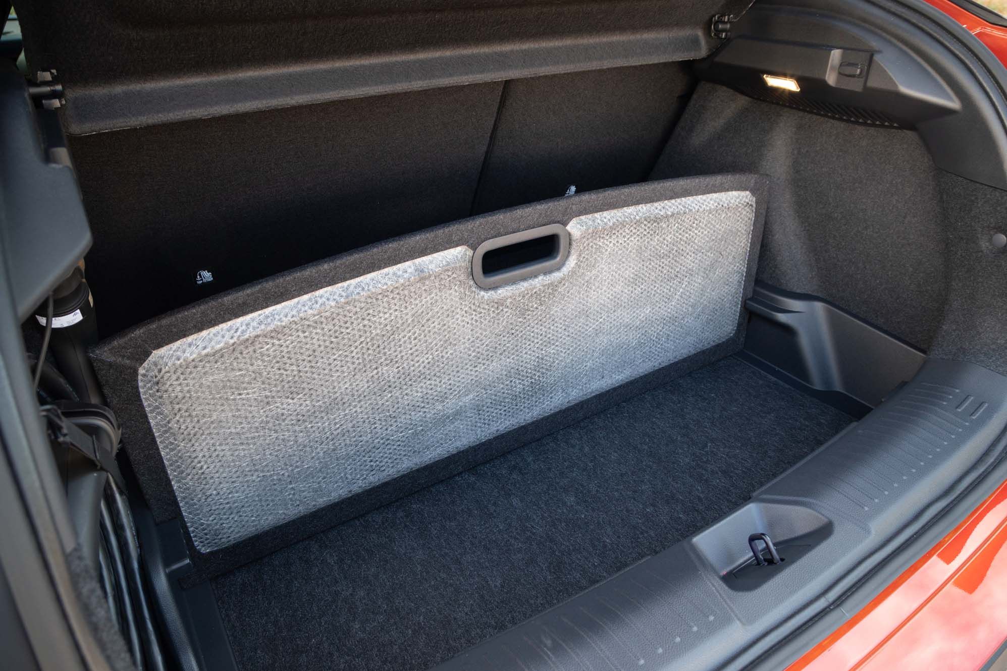 Open Nissan LEAF boot with a removable floor panel, revealing a storage compartment, lit by a small light on the side.