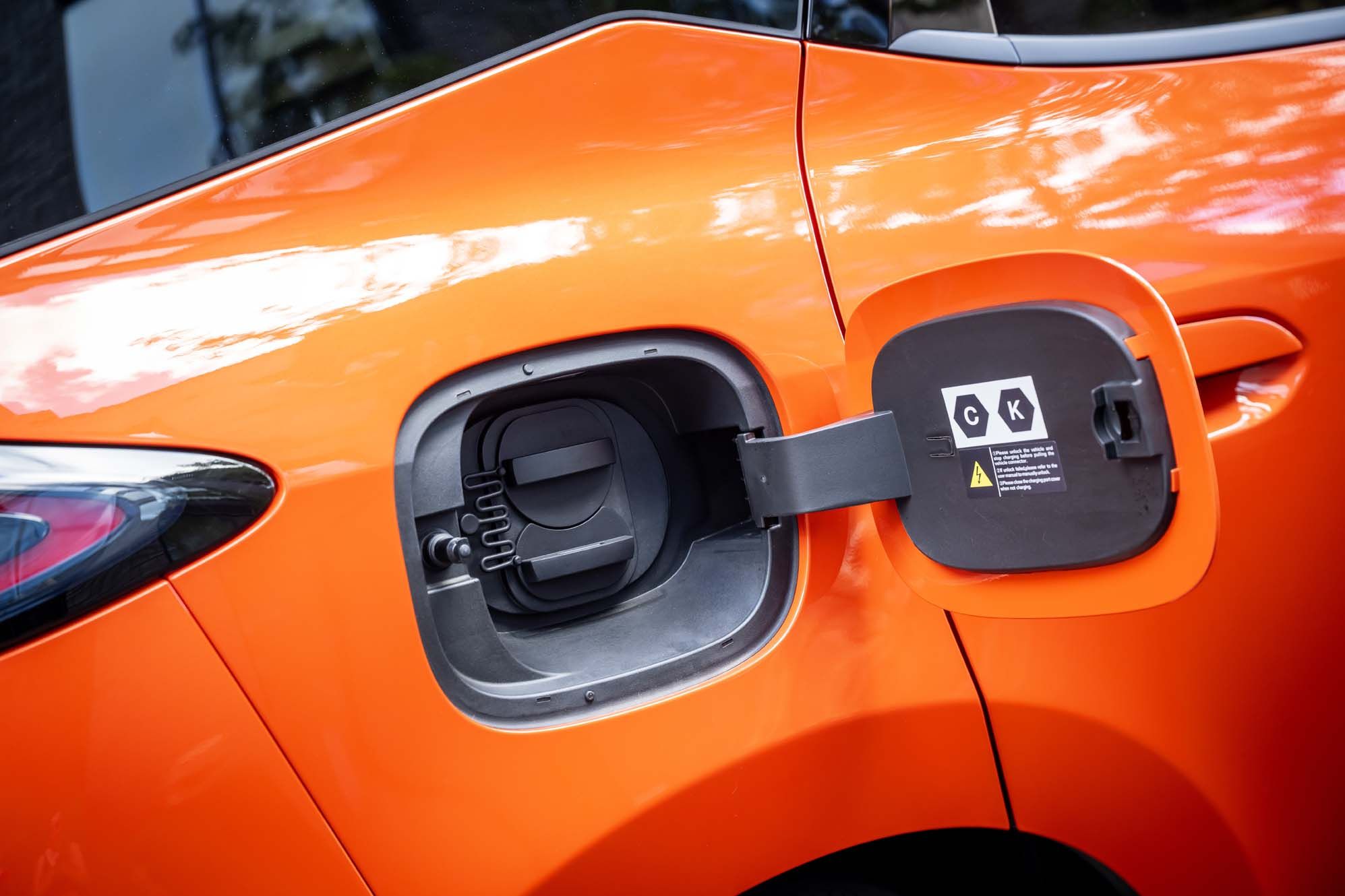 Orange BYD DOLPHIN G DM-i with an open electric charging port showing Type 2 and CCS ports.