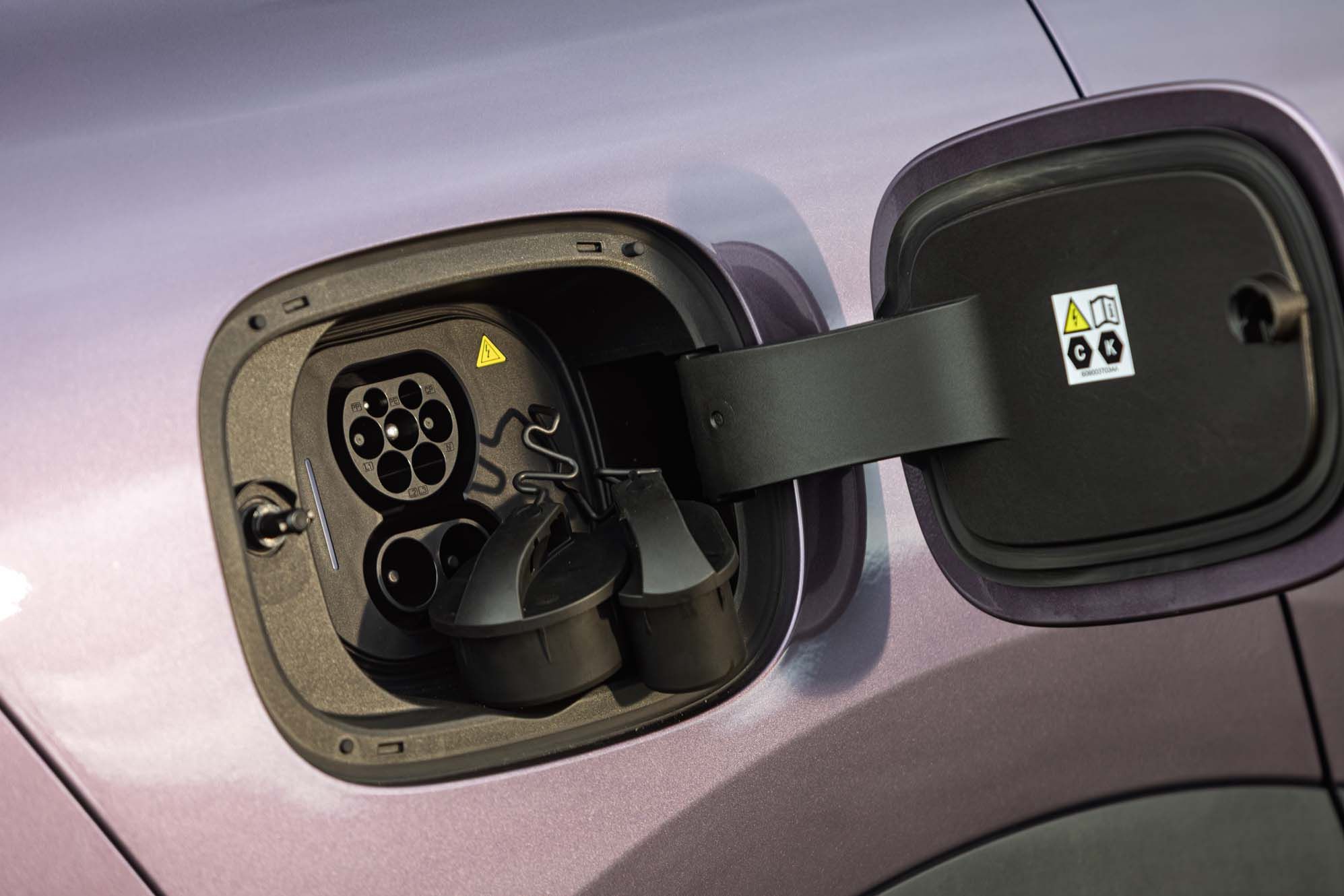Close-up of a LEPAS L8's charging port open, showing the plug connectors and cover on a purple vehicle.