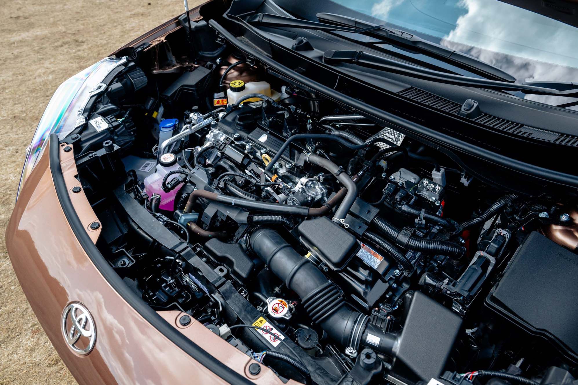 Open Toyota Yaris Cross bonnet showing a clean engine compartment with various components and fluid reservoirs visible.