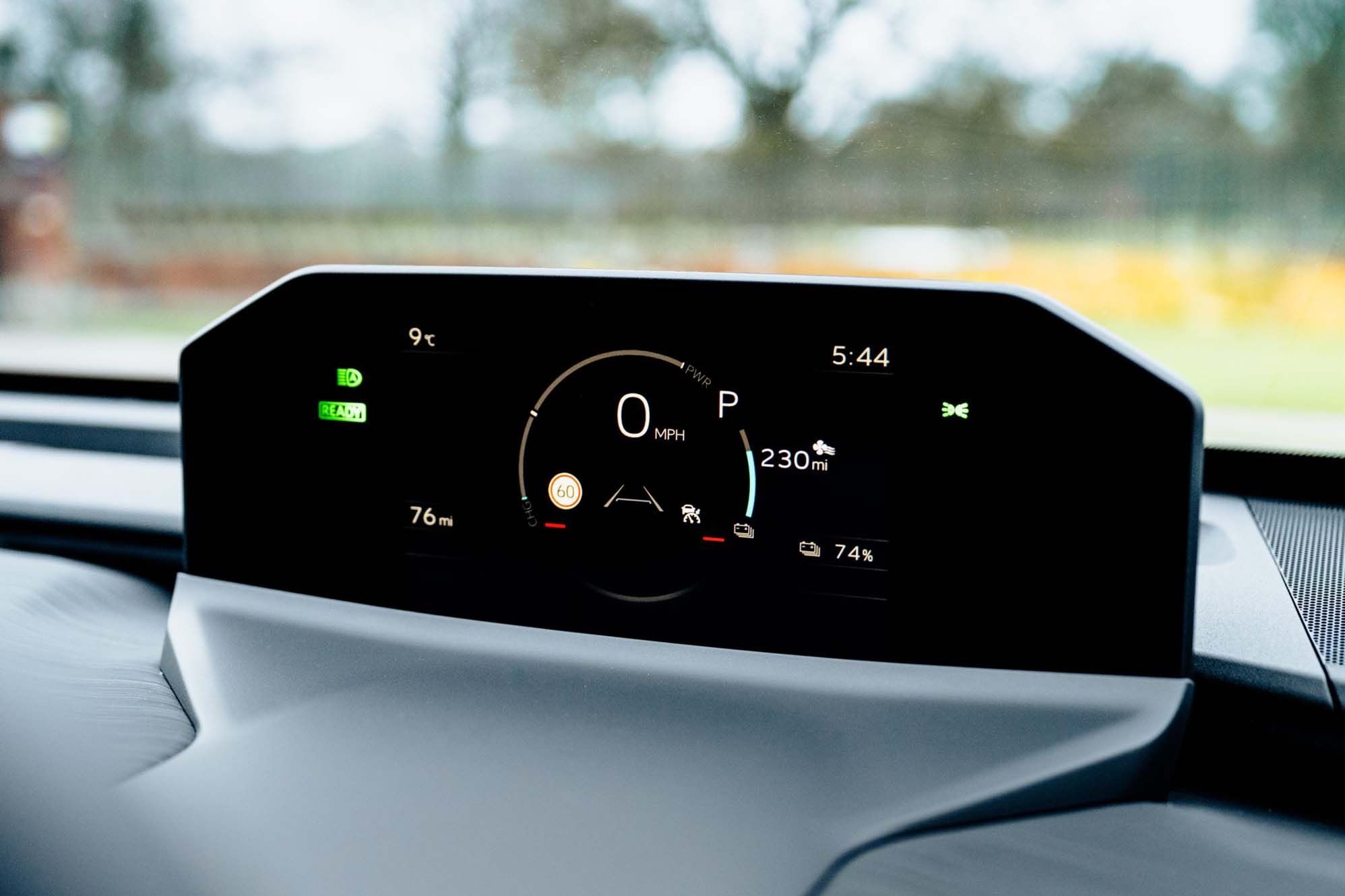 Close-up of a Toyota C-HR+'s dashboard showing 0 MPH, 230 miles range, 74% battery, and external temperature of 9°C at 5:44.