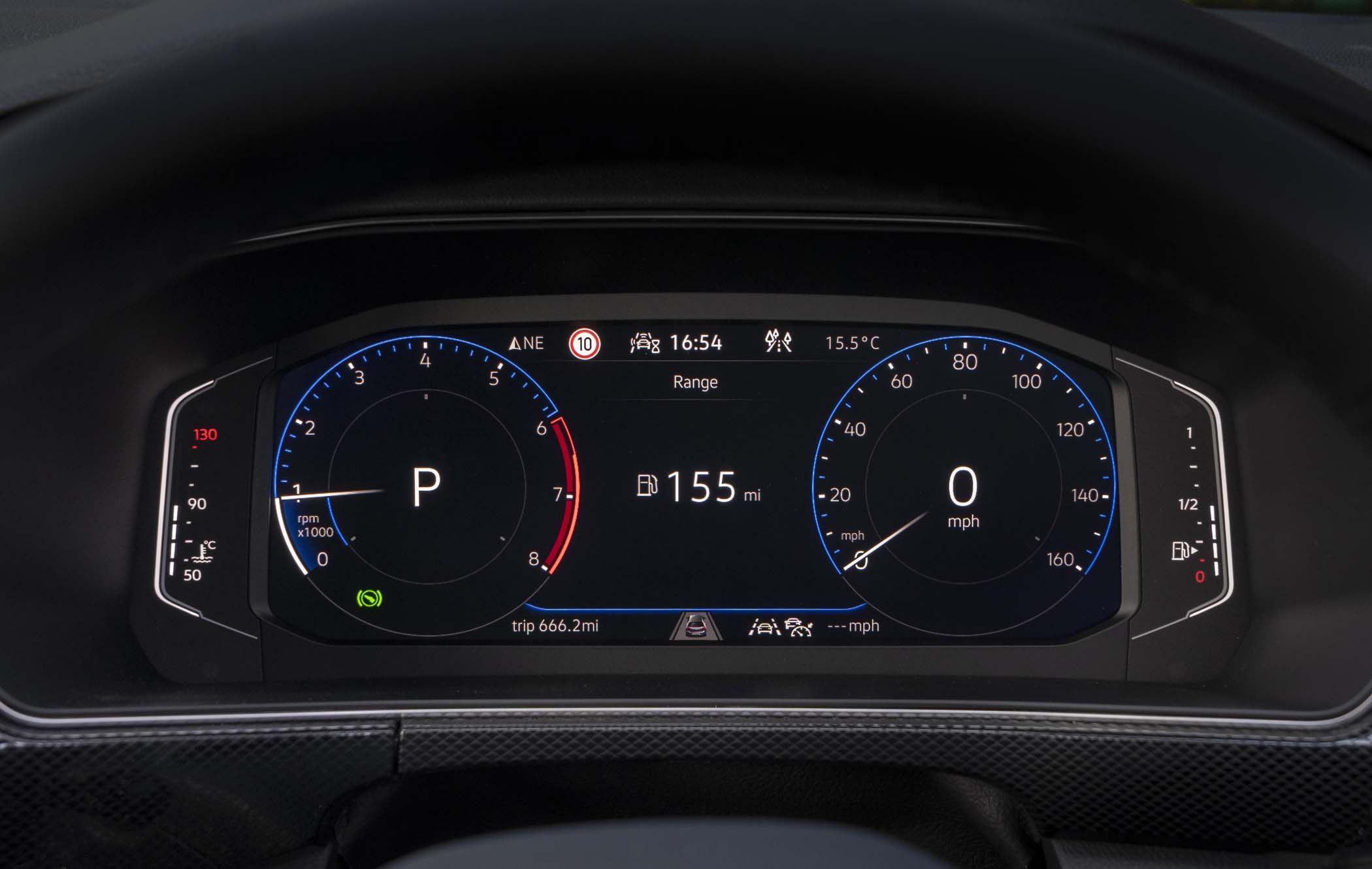 Digital VW T-Cross dashboard displaying speedometer, tachometer, and other indicators. Shows "P" for park and "155 mi" fuel range.