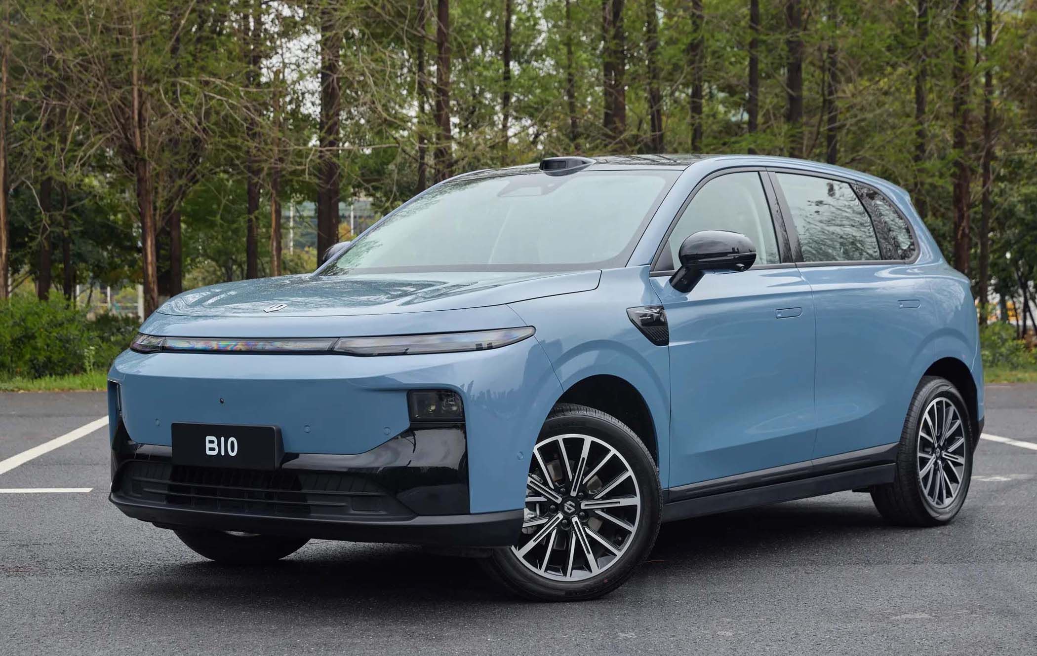 A blue Leapmotor B10 parked on a road, surrounded by trees. The car features sleek lines and modern design elements.