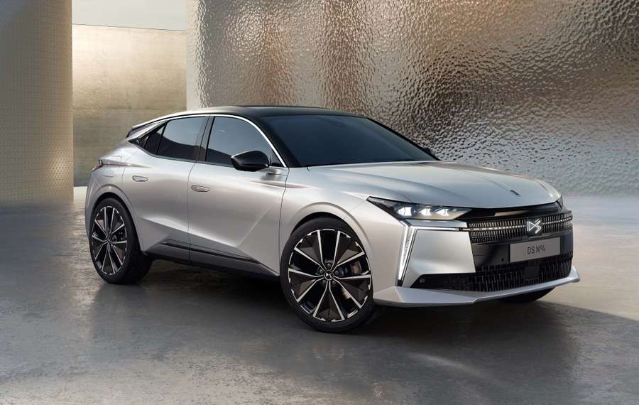 A silver DS No4 with modern design features, parked on a reflective surface with a textured metallic background.