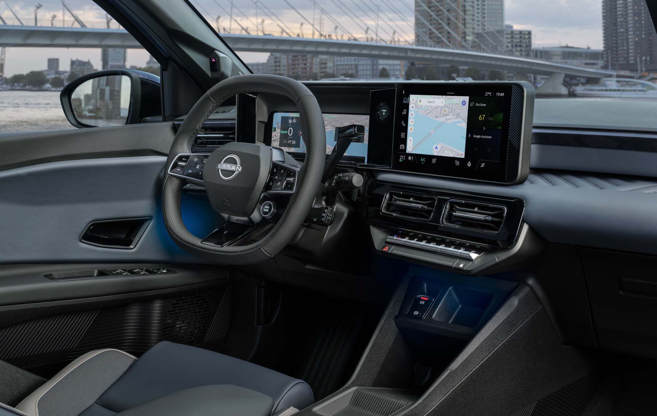Nissan MICRA interior featuring a steering wheel and a digital dashboard with navigation display, overlooking a city skyline through the window.