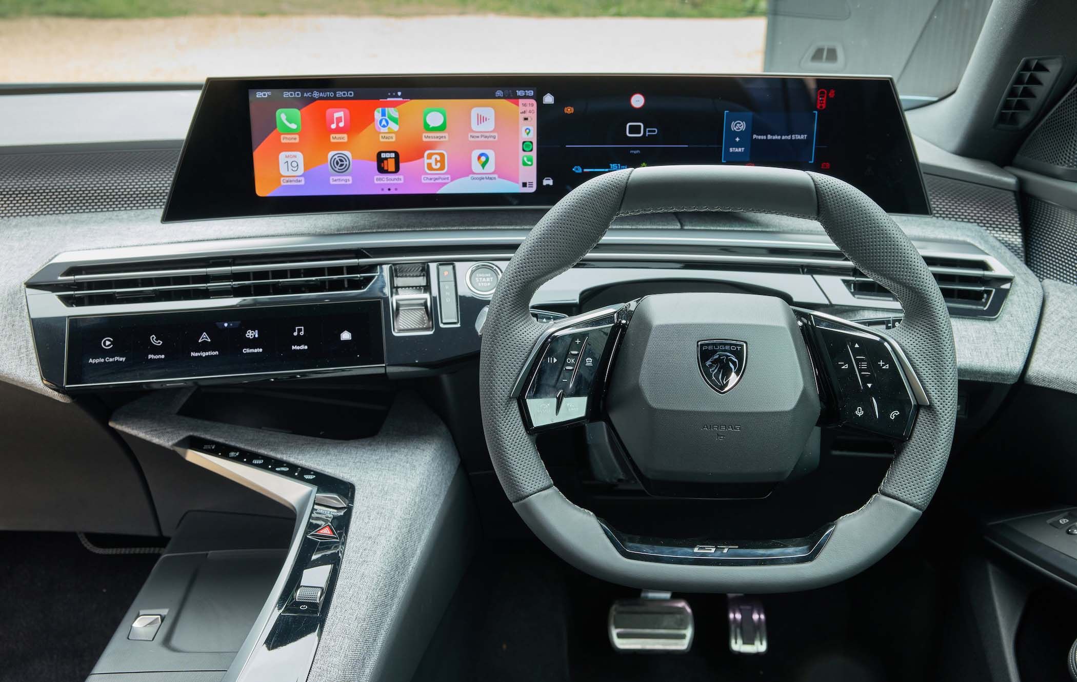 Peugeot 5008 interior with a digital dashboard, touchscreen displays showing apps, and a sleek steering wheel featuring a logo.