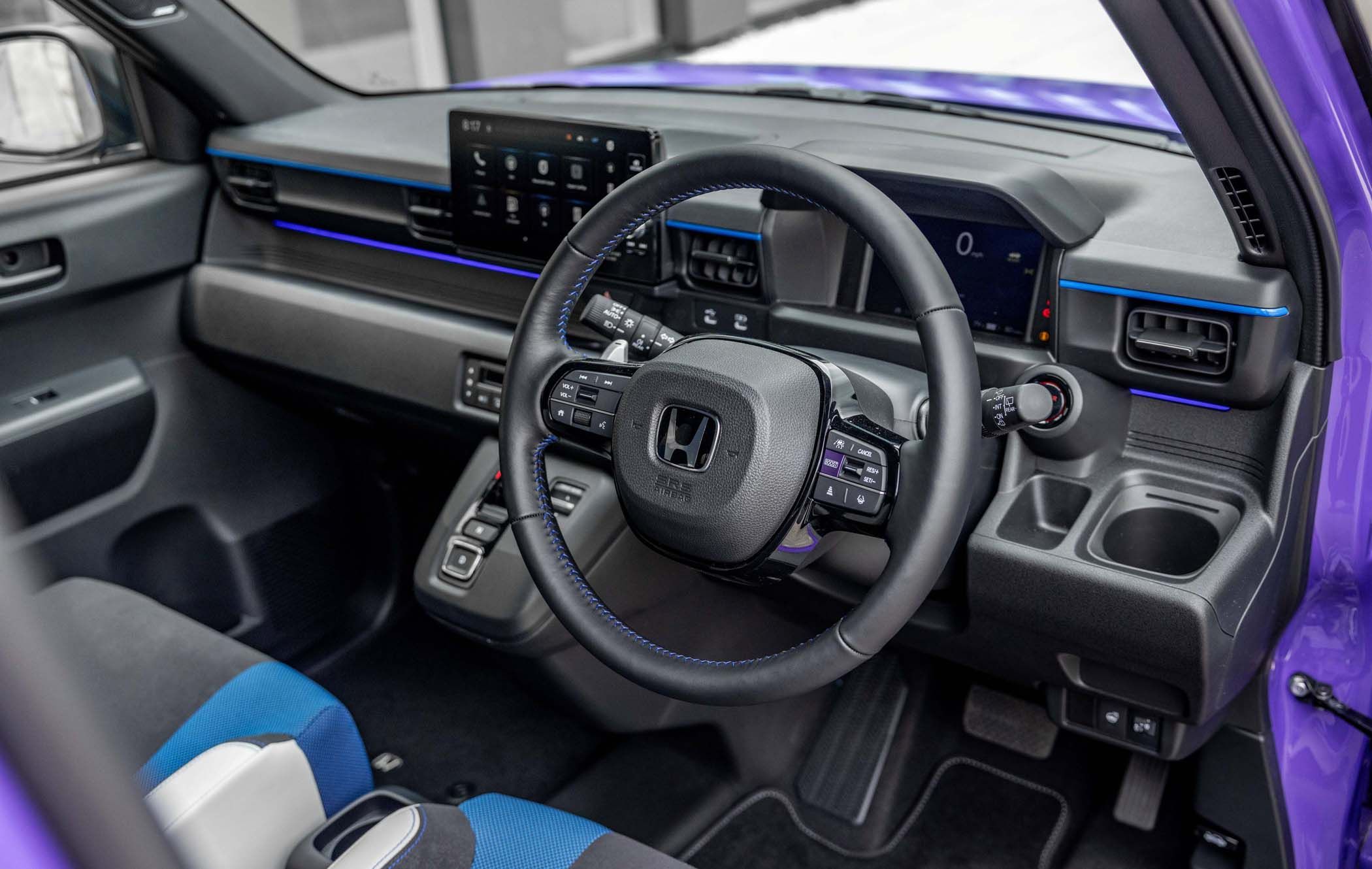 Honda Super-N interior with a modern dashboard, touchscreen display, steering wheel with controls, and blue accents on black and grey upholstery.