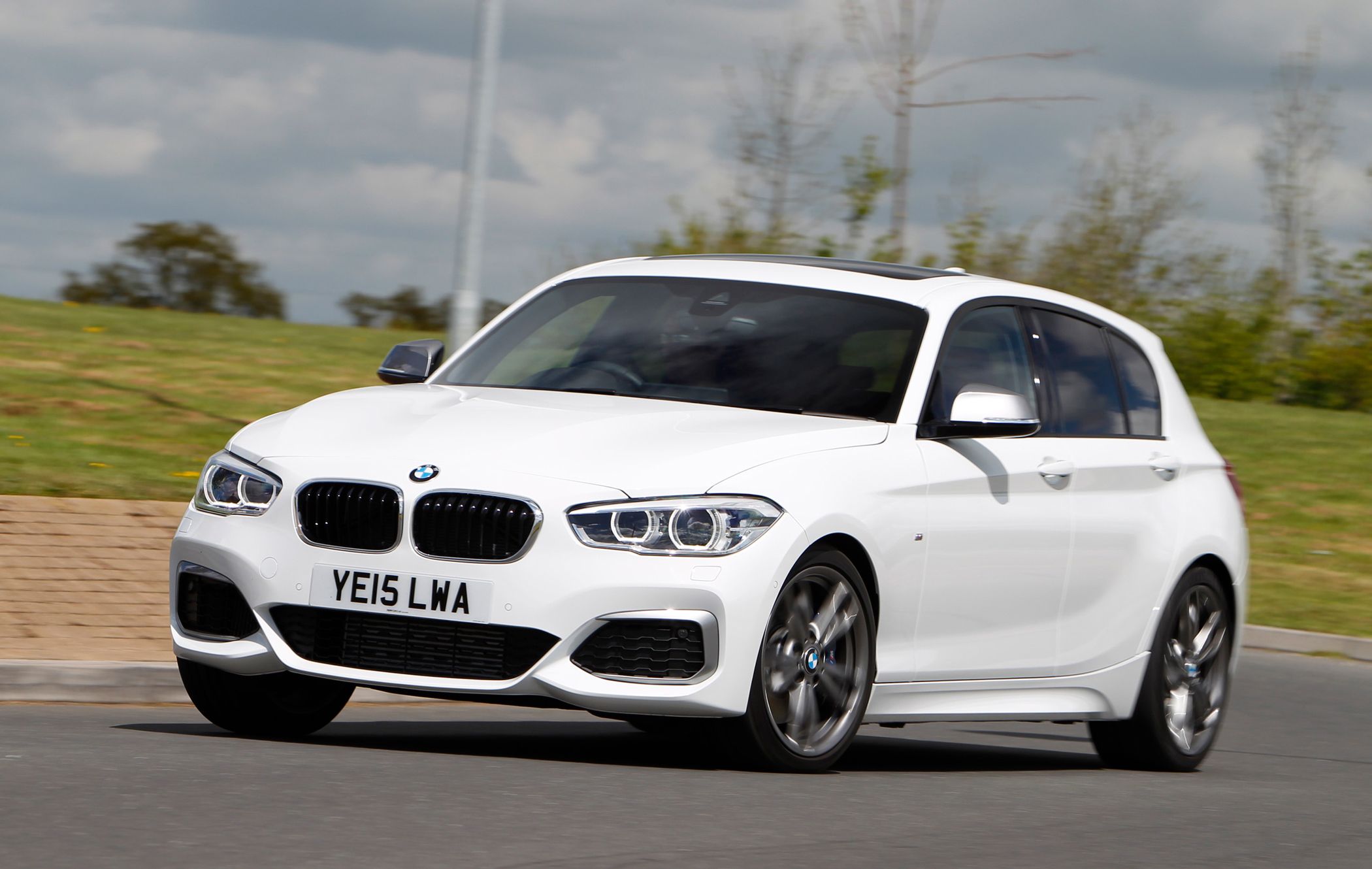 a white bmw 1 series driving