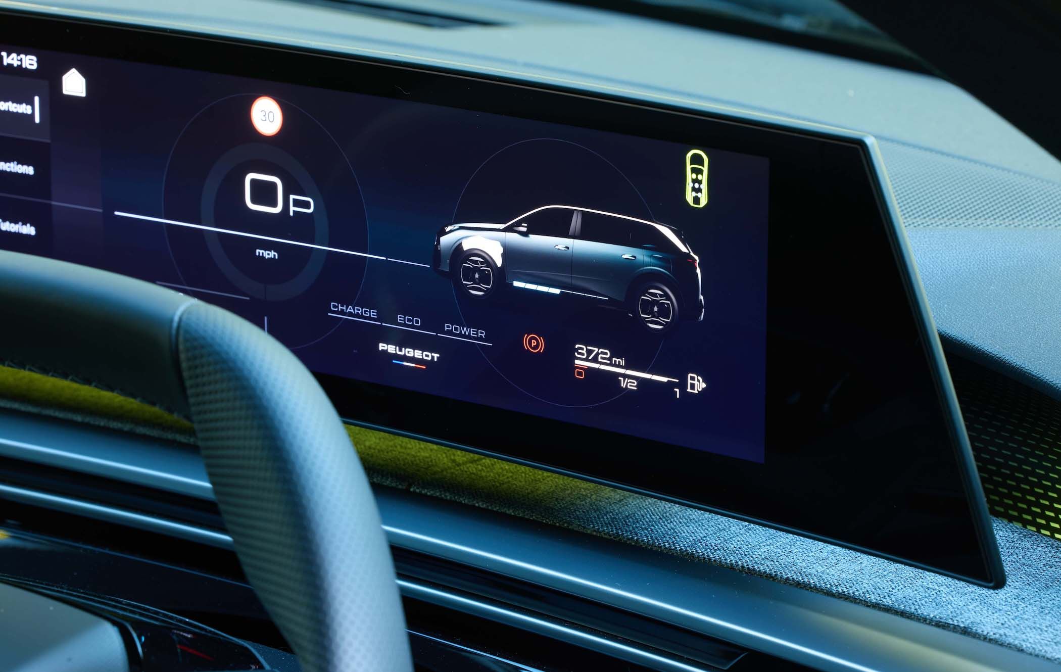 Close-up of a Peugeot 5008 dashboard displaying a digital screen with a vehicle graphic, speedometer, and battery level indicator.