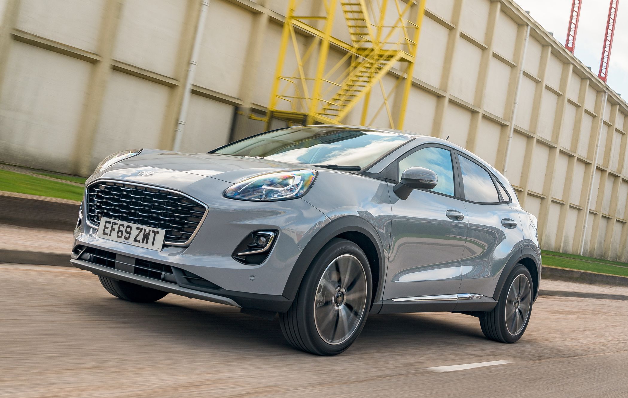 a grey ford puma driving on a road