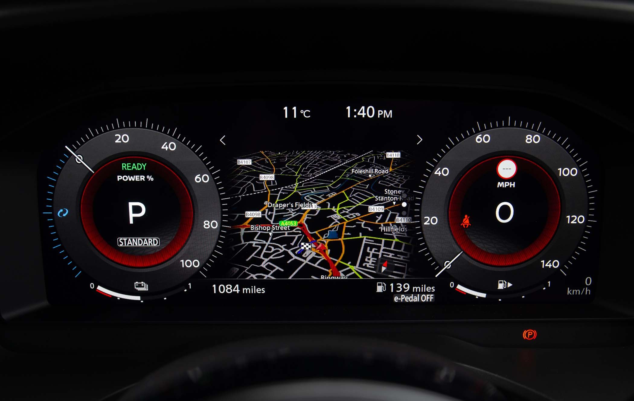 Nissan X-Trail dashboard display showing digital speedometer, gear in park, map with route, temperature at 11°C, and time at 1:40 PM.