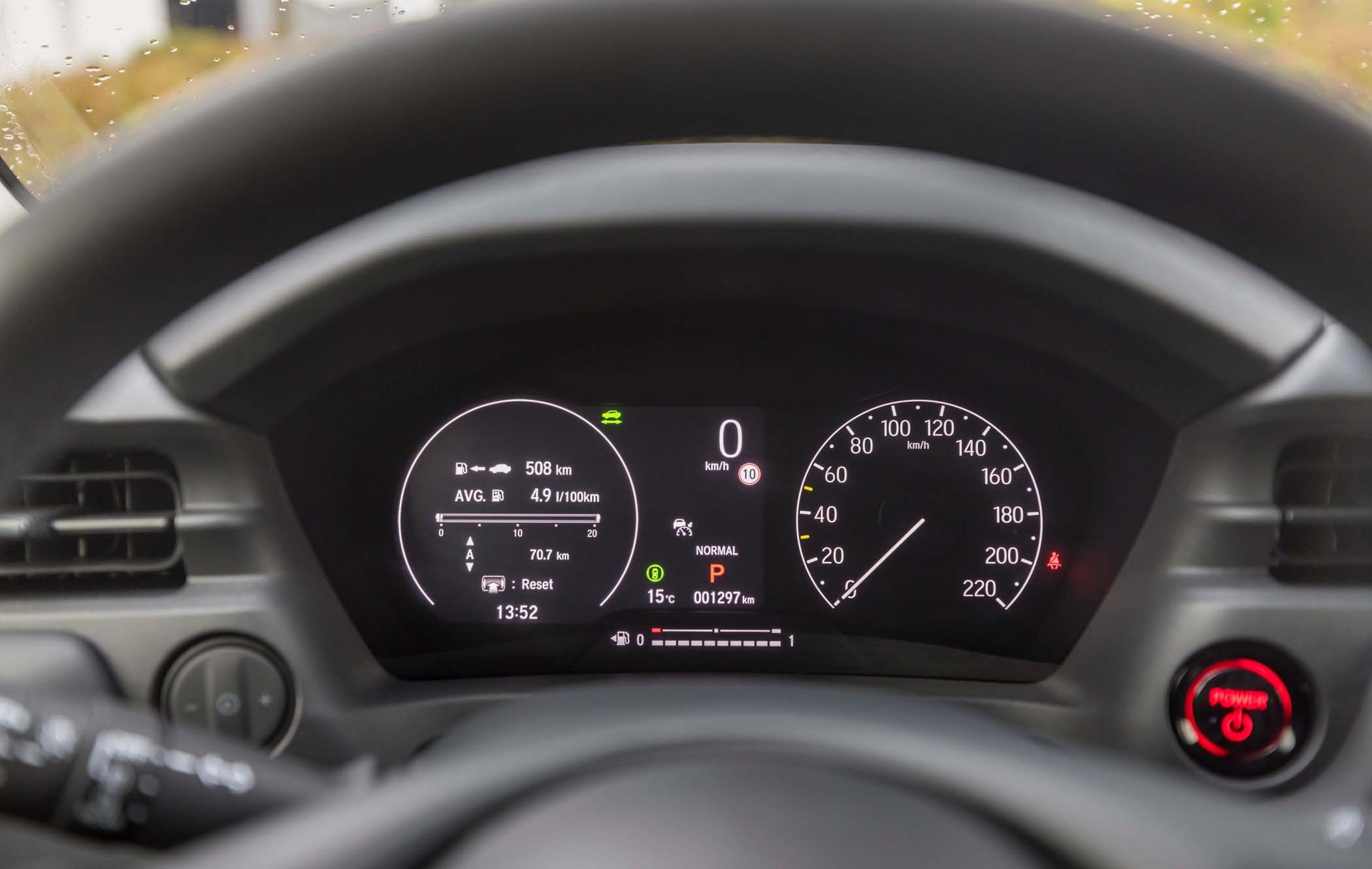 Close-up of a Honda HR-V dashboard showing digital speedometer, fuel range, and odometer. Gear is in park, with various indicators lit.