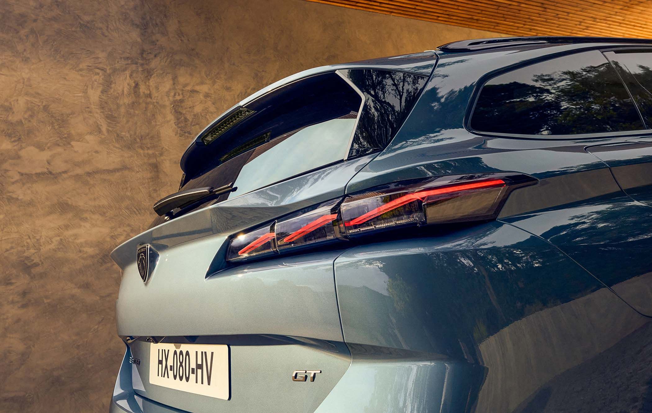 Close-up of a Peugeot 308 SW's rear, showcasing modern taillights and a distinctive logo, against a textured beige wall background.