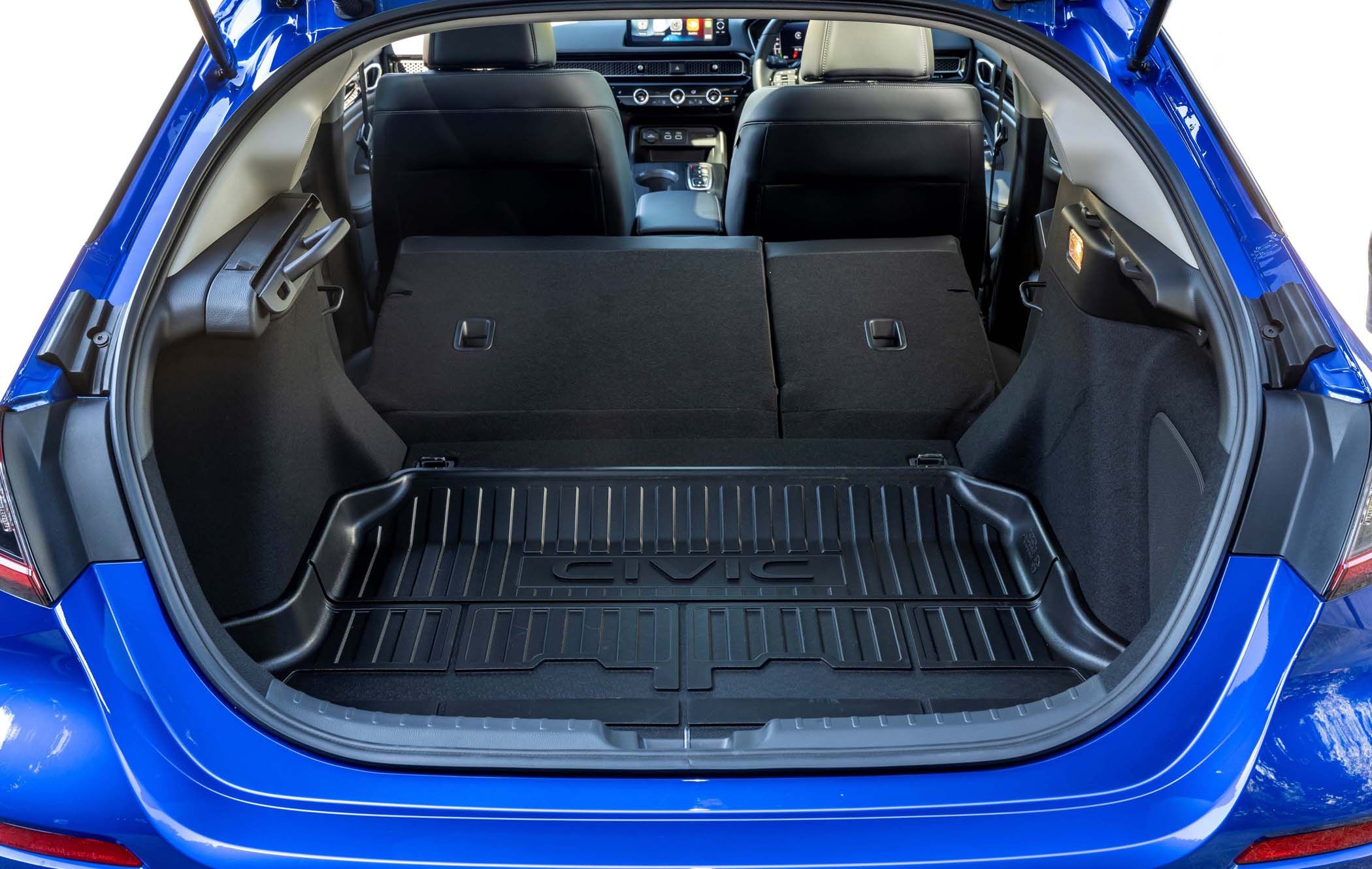 Open boot of a blue Honda Civic with rear seats folded down, revealing a spacious luggage area with a protective mat labeled "Civic."