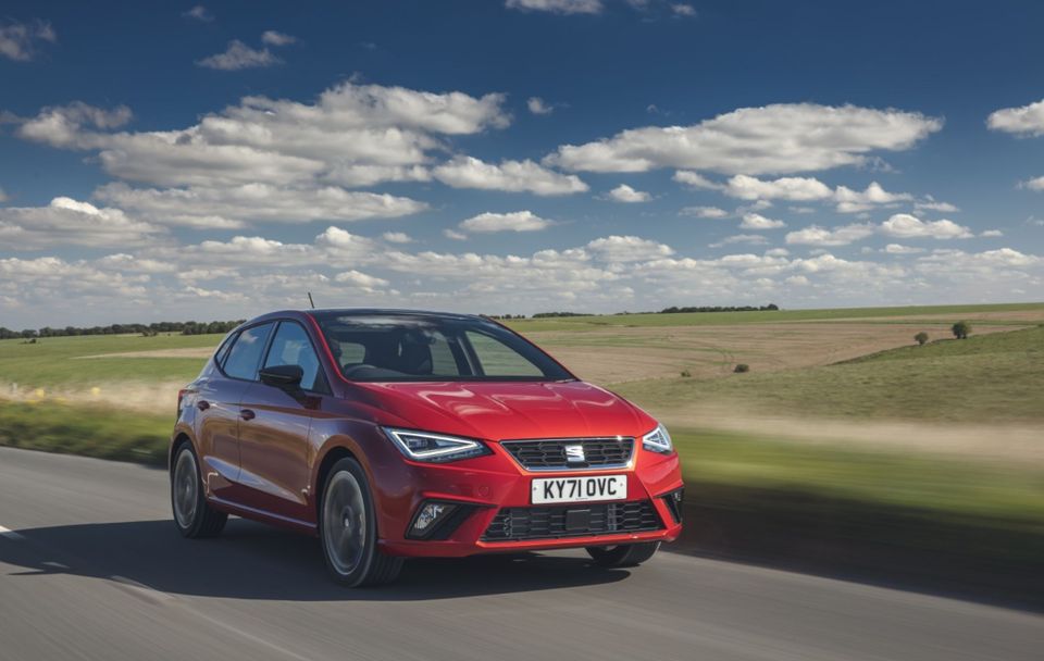 Red SEAT Ibiza driving on country road
