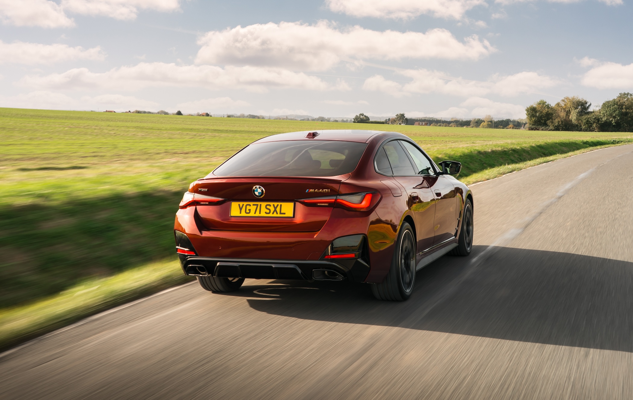 Red BMW 4 Series Gran Coupe driving away