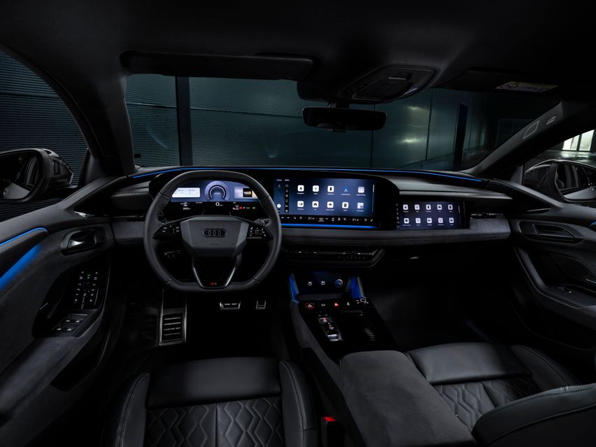 Futuristic car interior featuring a sleek dashboard with multiple digital displays, a modern steering wheel, and leather seats, illuminated softly.