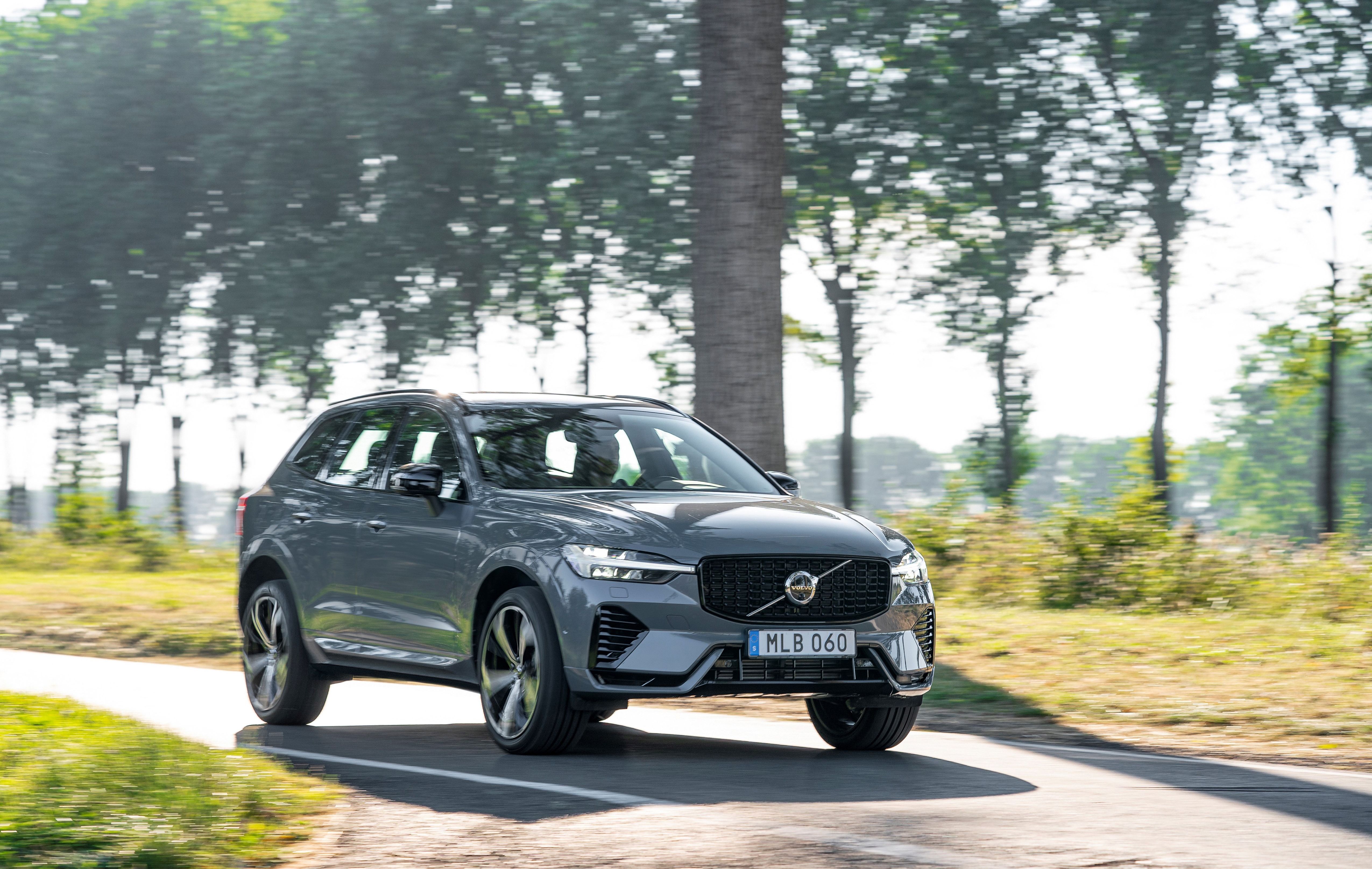 a dark grey volvo xc60 driving down a country road