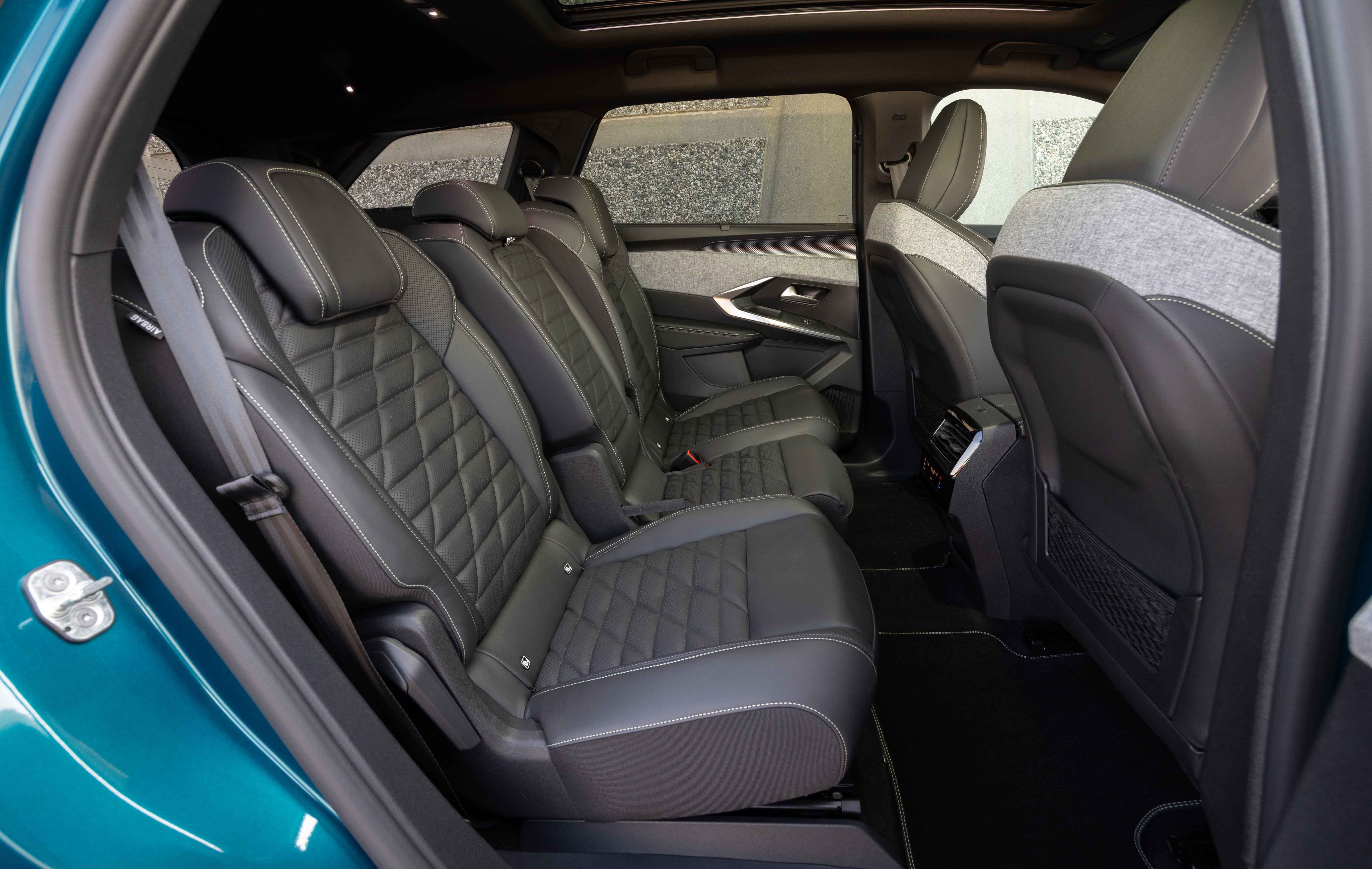 Interior view of a Peugeot 5008 showcasing two rows of black leather seats with diamond stitching, emphasising spacious and luxurious design.