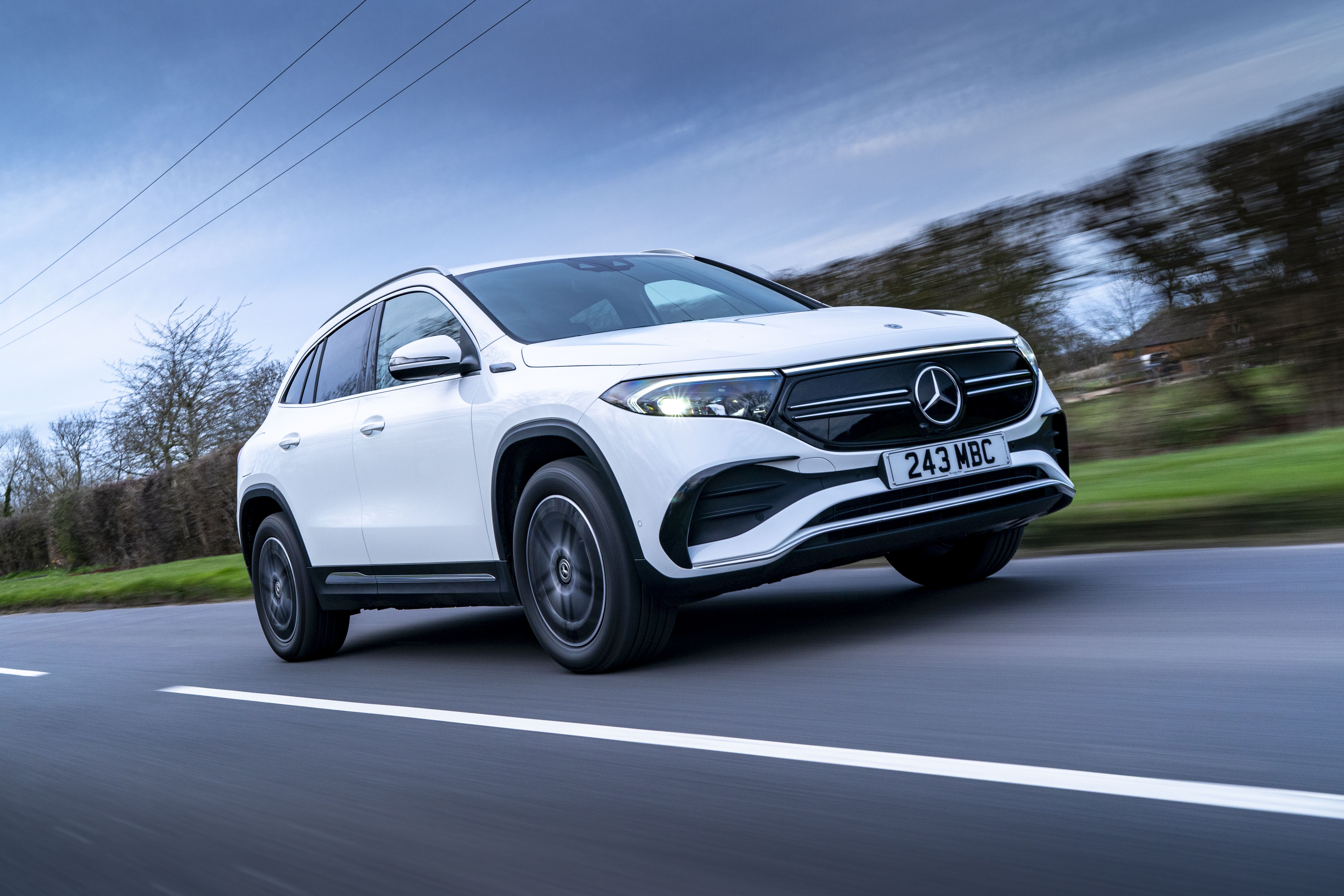 white mercedes eqa driving on a countryside road 