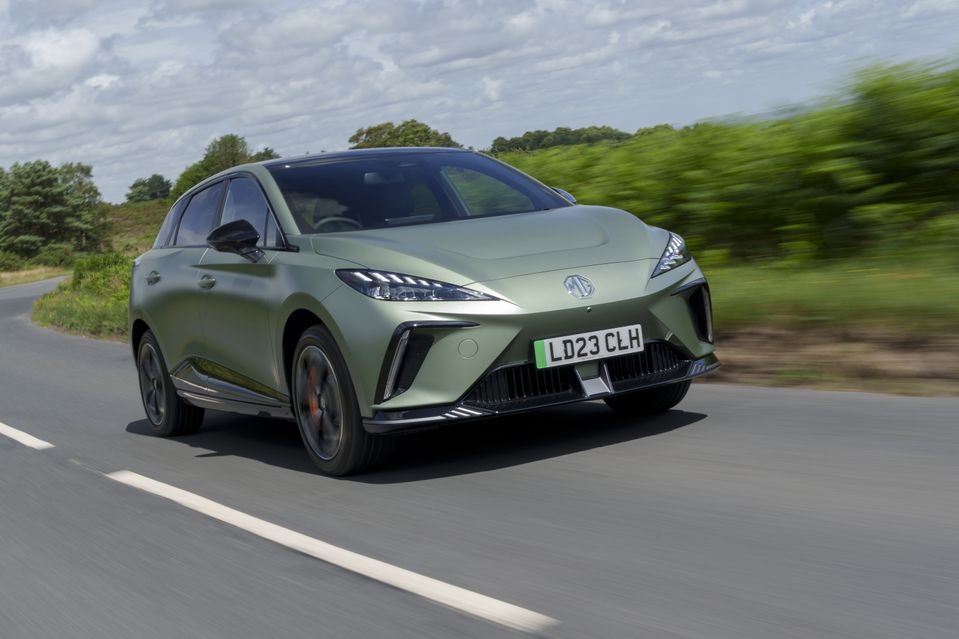 a green MG4 XPower driving on a country road in the UK