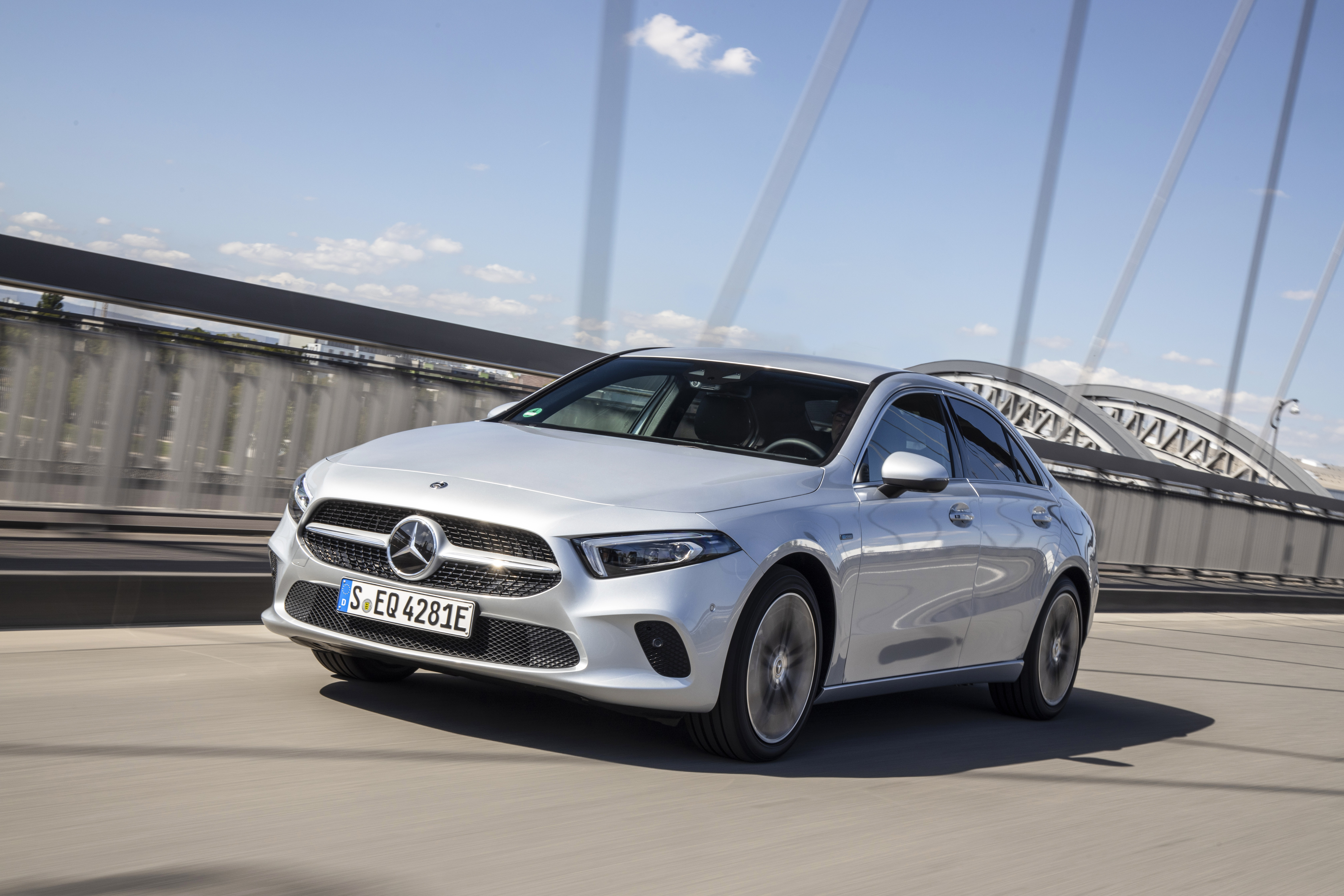 a silver mercedes a-class plug-in hybrid driving over a bridge in europe