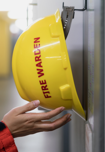 Person placing fire warden helmet on hook