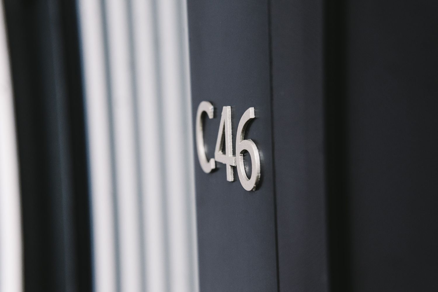 Close up of a metal letters and numbers affixed to a black wall