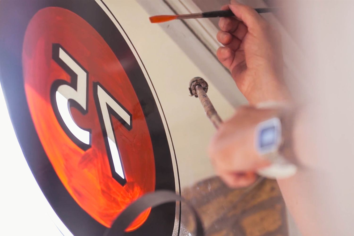 Our signwriter using a Mahl Stick and chisel tip brush to finish off the hand painting part of our vintage shop sign