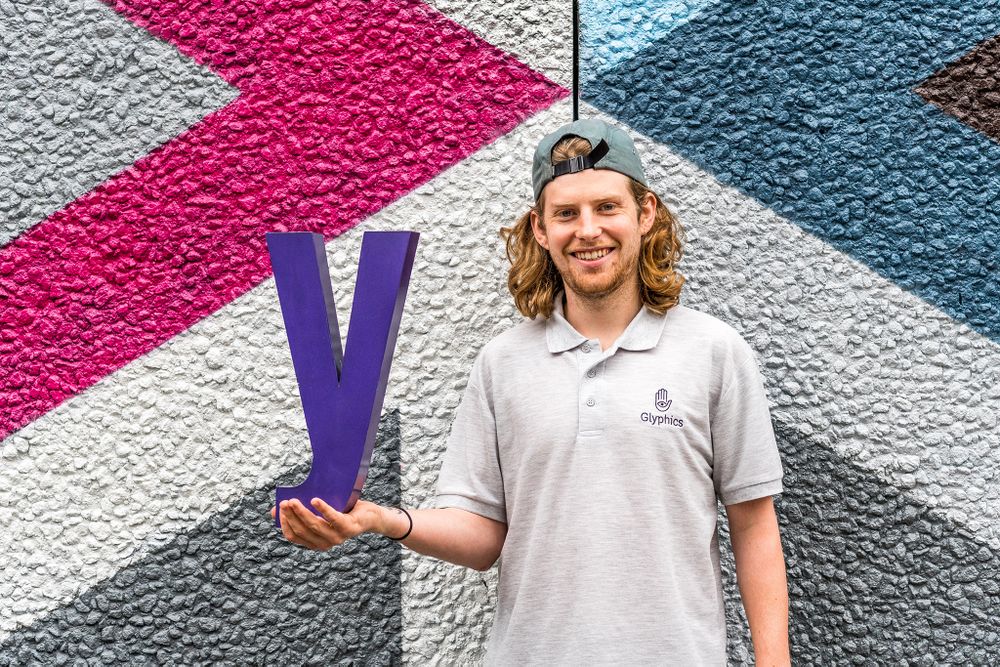 Ryan holding a deep purple metal letter Y