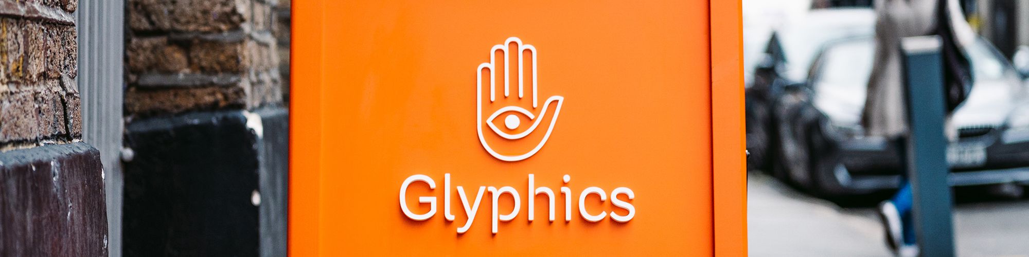 Bright orange pavement board with Glyphics logo