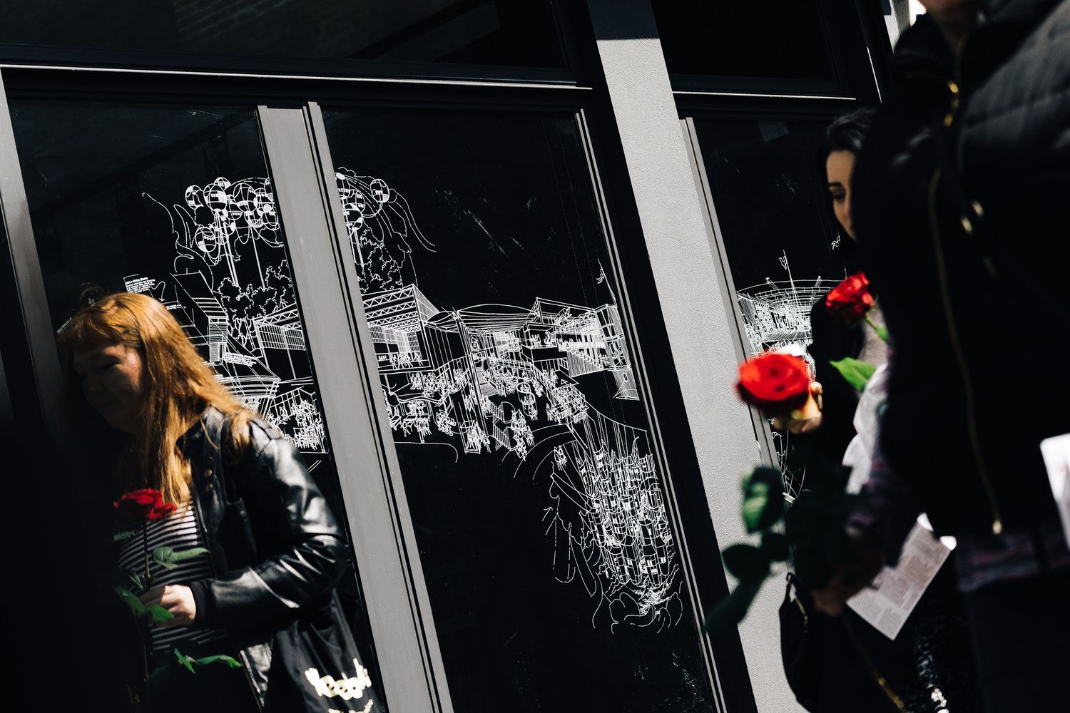 Picture of passers in front of a huge window vinyl panel that appeared to have been etched with an architectural drawing at Mackenzie Wheeler office in Shoreditch