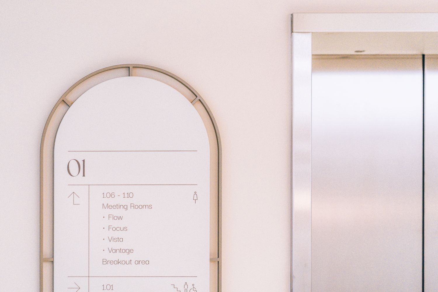 Close up of the curved metal framed Ellisse directory, part of the bespoke office wayfinding system.