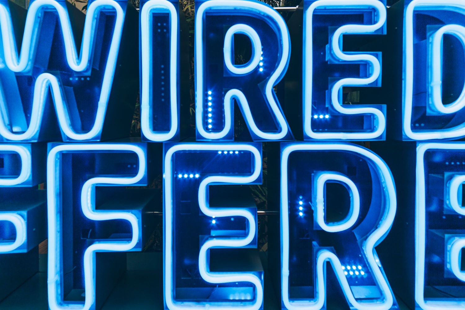 A close up of the WIRED DIFFERENTLY bue neon sign