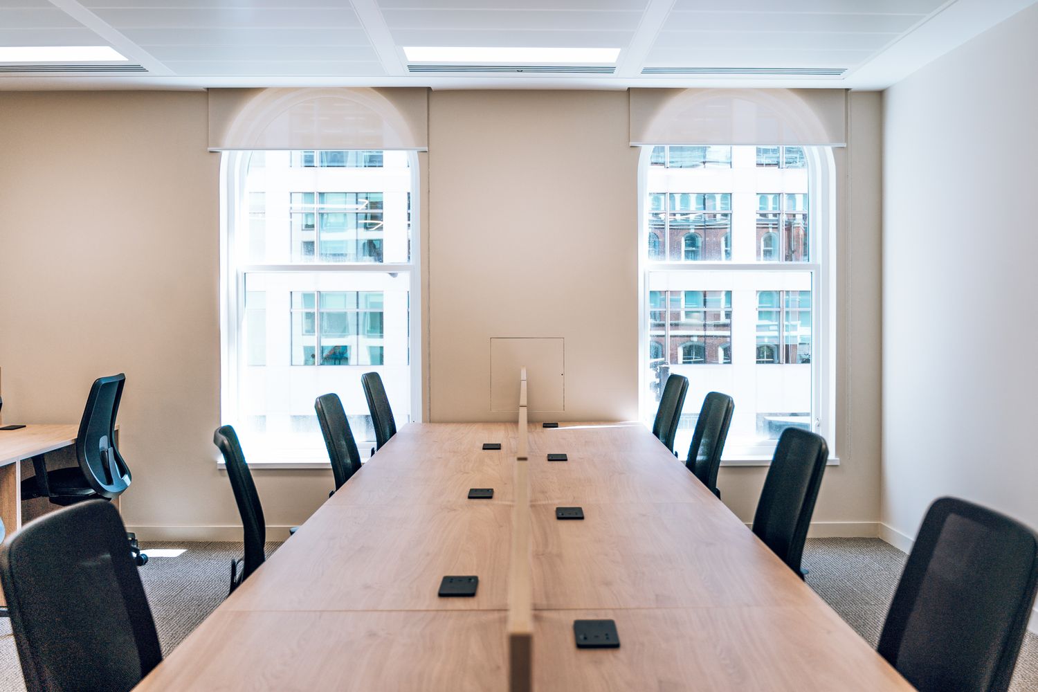 Ellisse meeting room interior showing the premium co-working workspace and architectural arched windows.