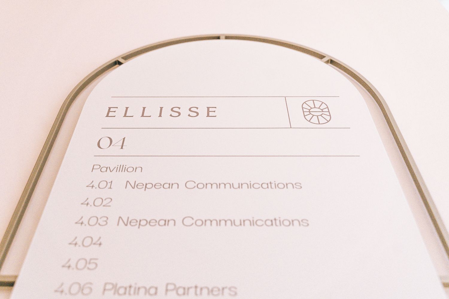Close up of the Ellisse 3D directory signage, showing branded typography and tenant information within the curved metal frame.