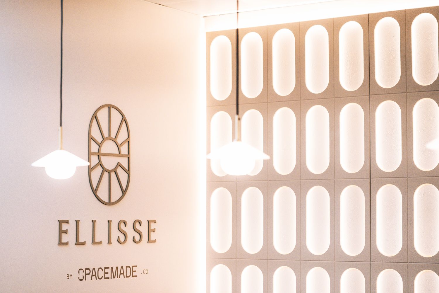 Ellisse reception branding and illuminated feature wall, combining bespoke metal signage with a large scale Art Deco inspired installation.