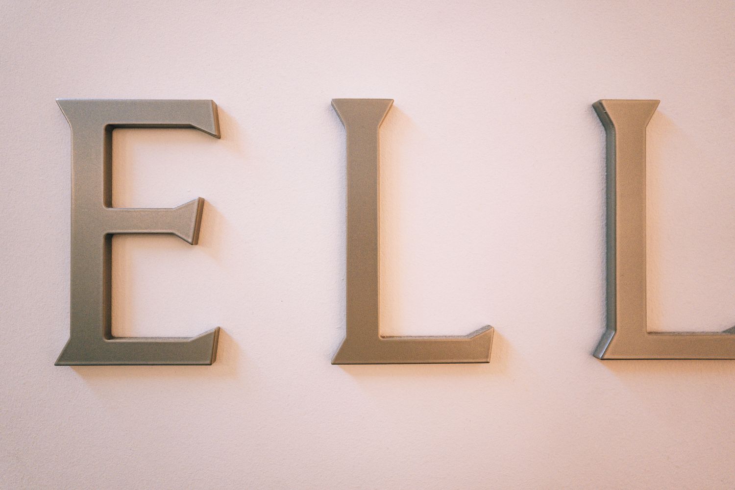 Detail of the 3D metal Ellisse reception lettering, finished to complement the wider workplace signage scheme.