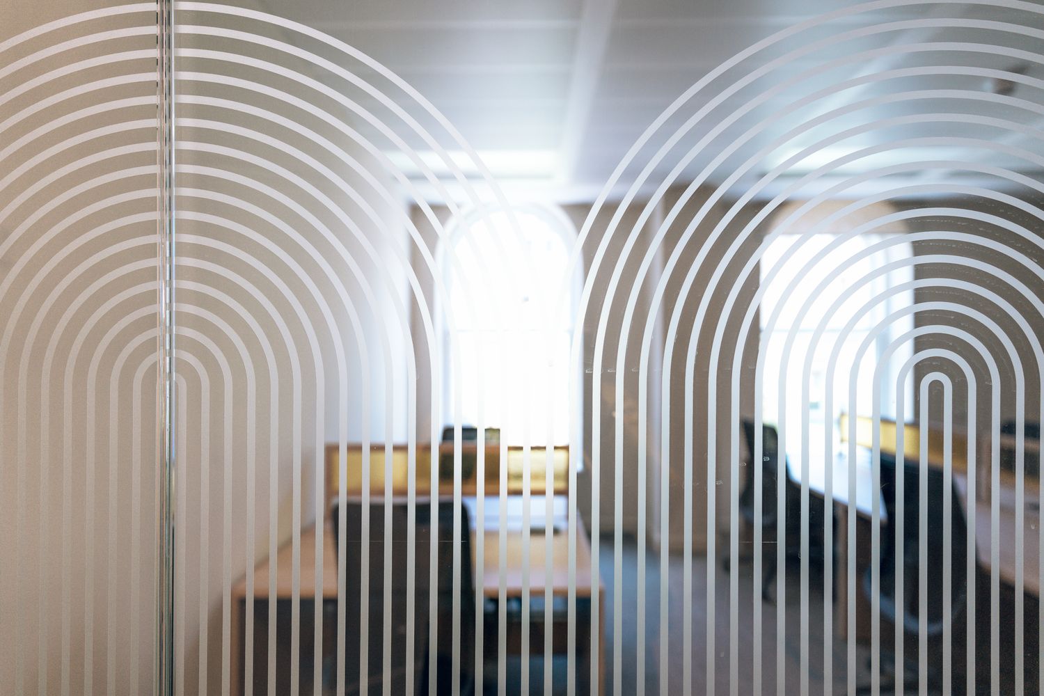 Art Deco inspired glass manifestation at Ellisse by Spacemade, creating branded privacy across a glazed meeting room.