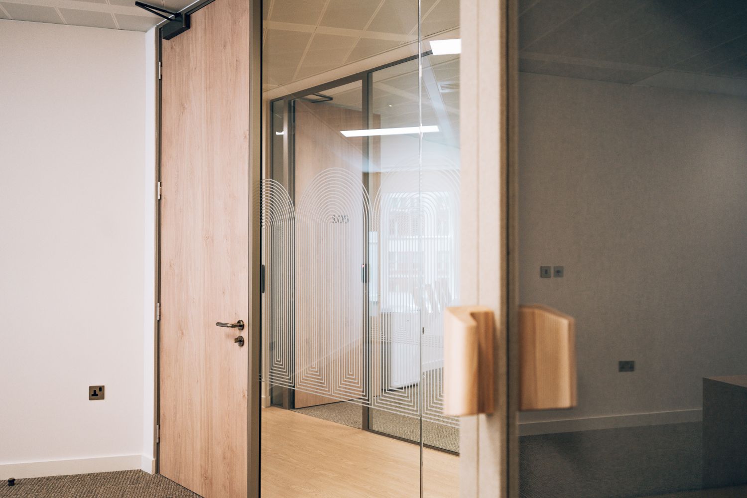 Branded glass manifestation at Ellisse by Spacemade, creating privacy and visibility across glazed office partitions.