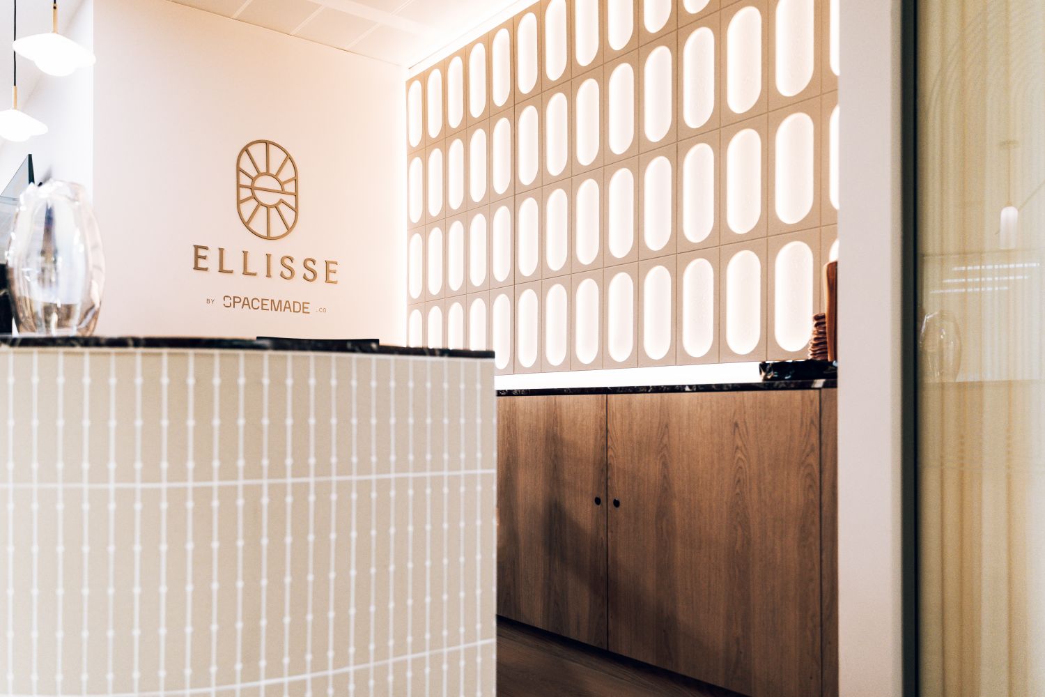 Ellisse by Spacemade reception featuring bespoke metal logo signage and a custom illuminated Art Deco inspired feature wall at 10 St Bride Street.