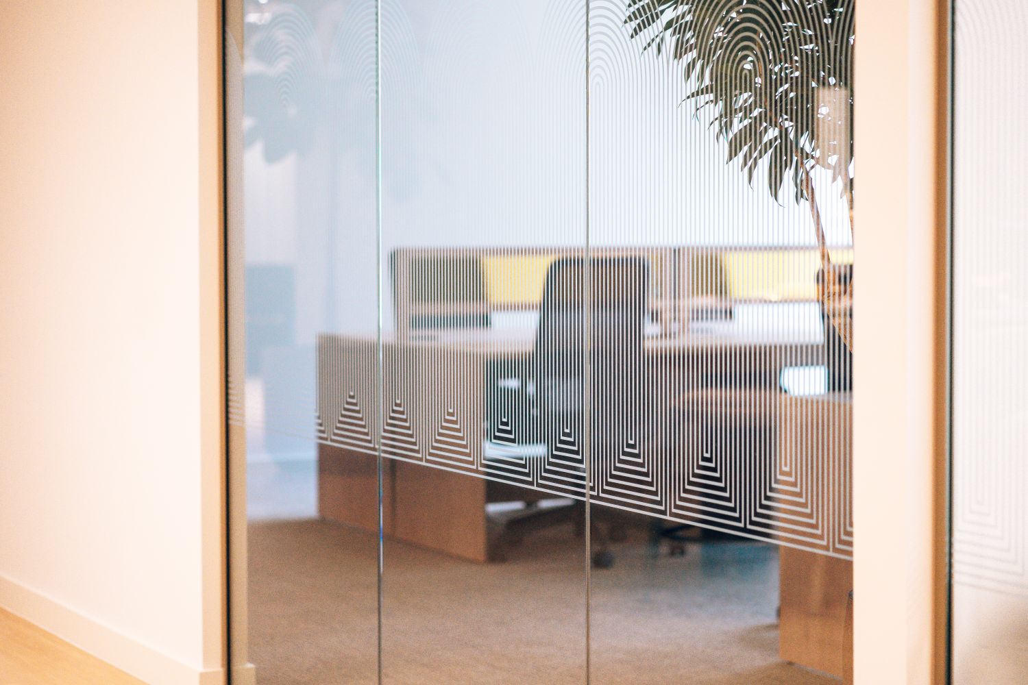 Art Deco inspired glass manifestation at Ellisse by Spacemade, using repeated ellipse forms to create privacy across glazed meeting room partitions.
