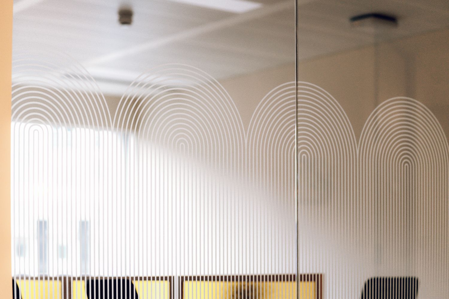 Large scale Art Deco glass manifestation across an Ellisse meeting room, combining workplace privacy with branded environmental graphics.
