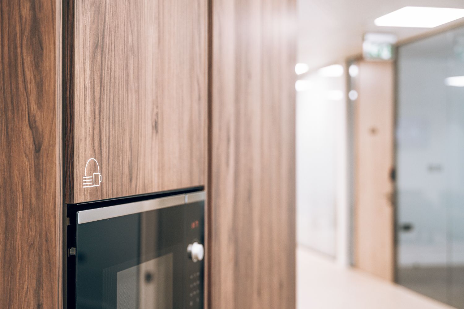 Kitchen amenity icons at Ellisse by Spacemade, produced as subtle surface cut vinyl graphics on timber cabinetry.