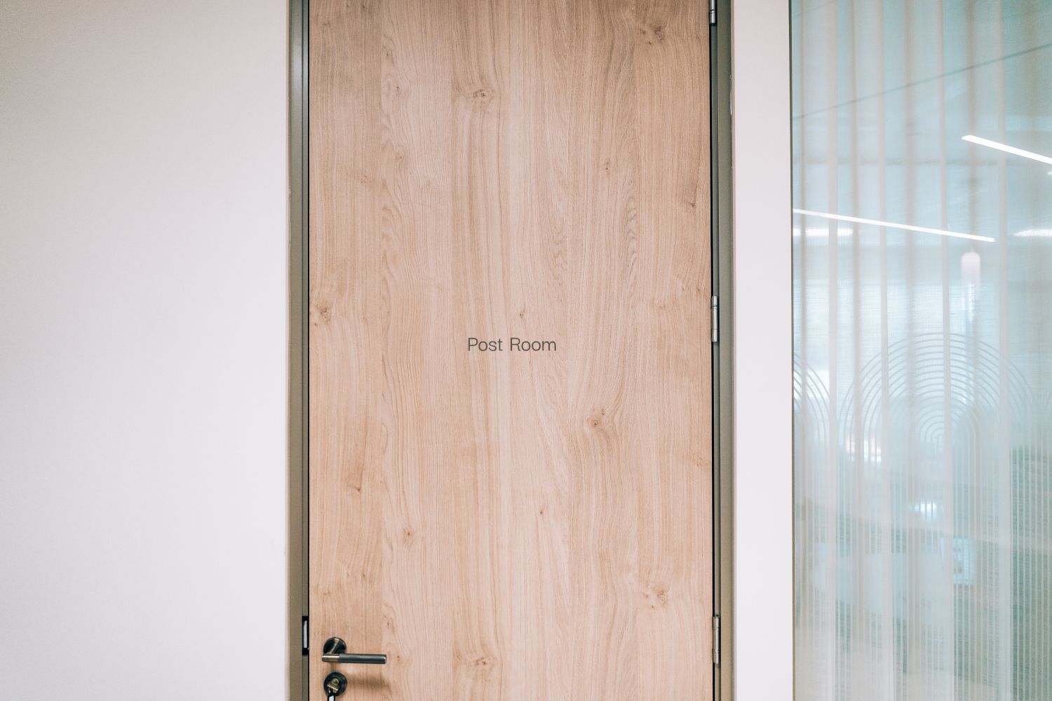 Post Room identification signage at Ellisse by Spacemade, applied directly to the timber door as part of the office signage system.