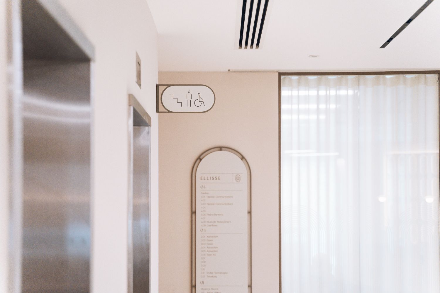 Ellisse office wayfinding showing a 3D directory and double-sided projecting sign within the coworking space.