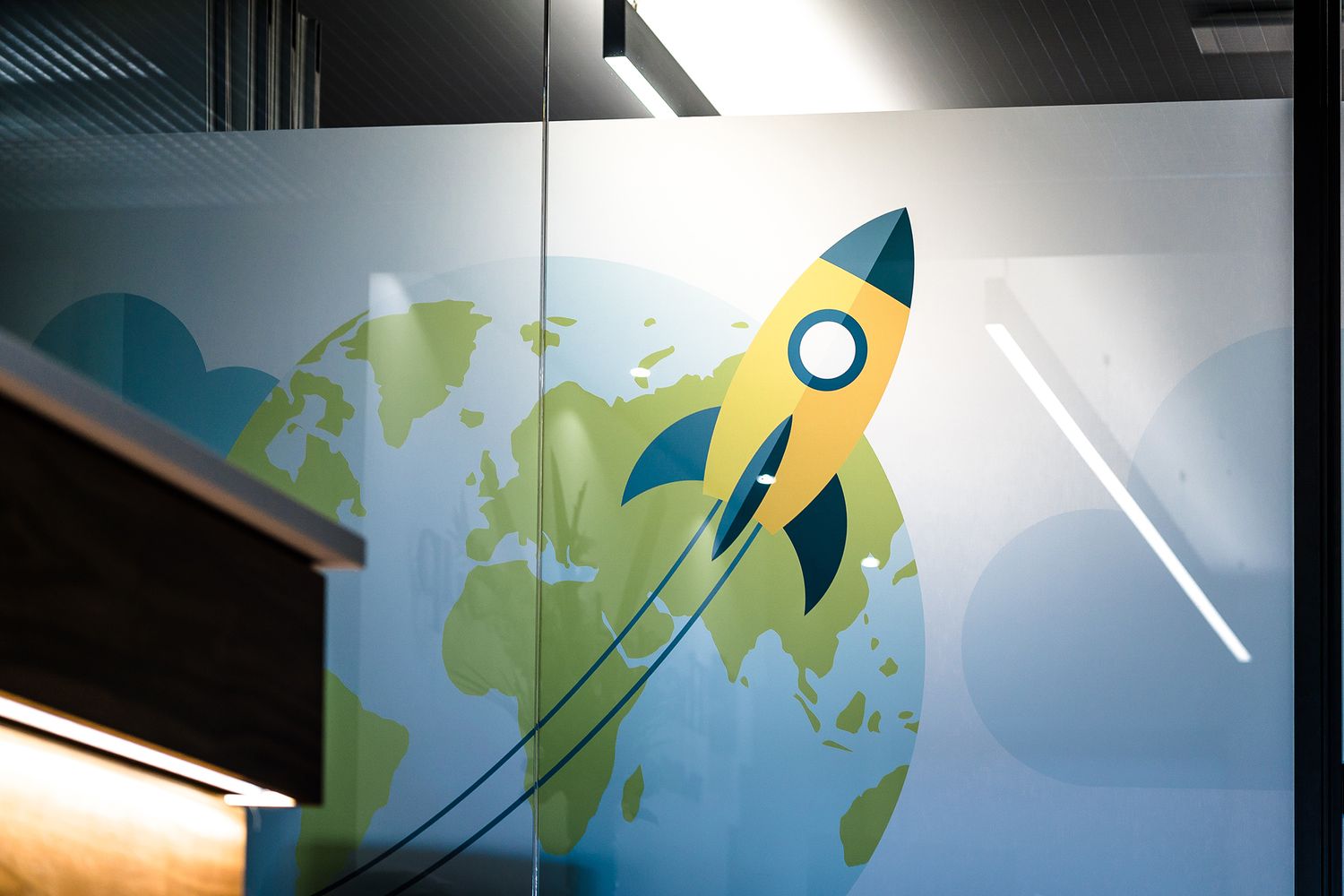 A fun yellow and blue rocket part of the office glass manifestation of the Hackett Group.