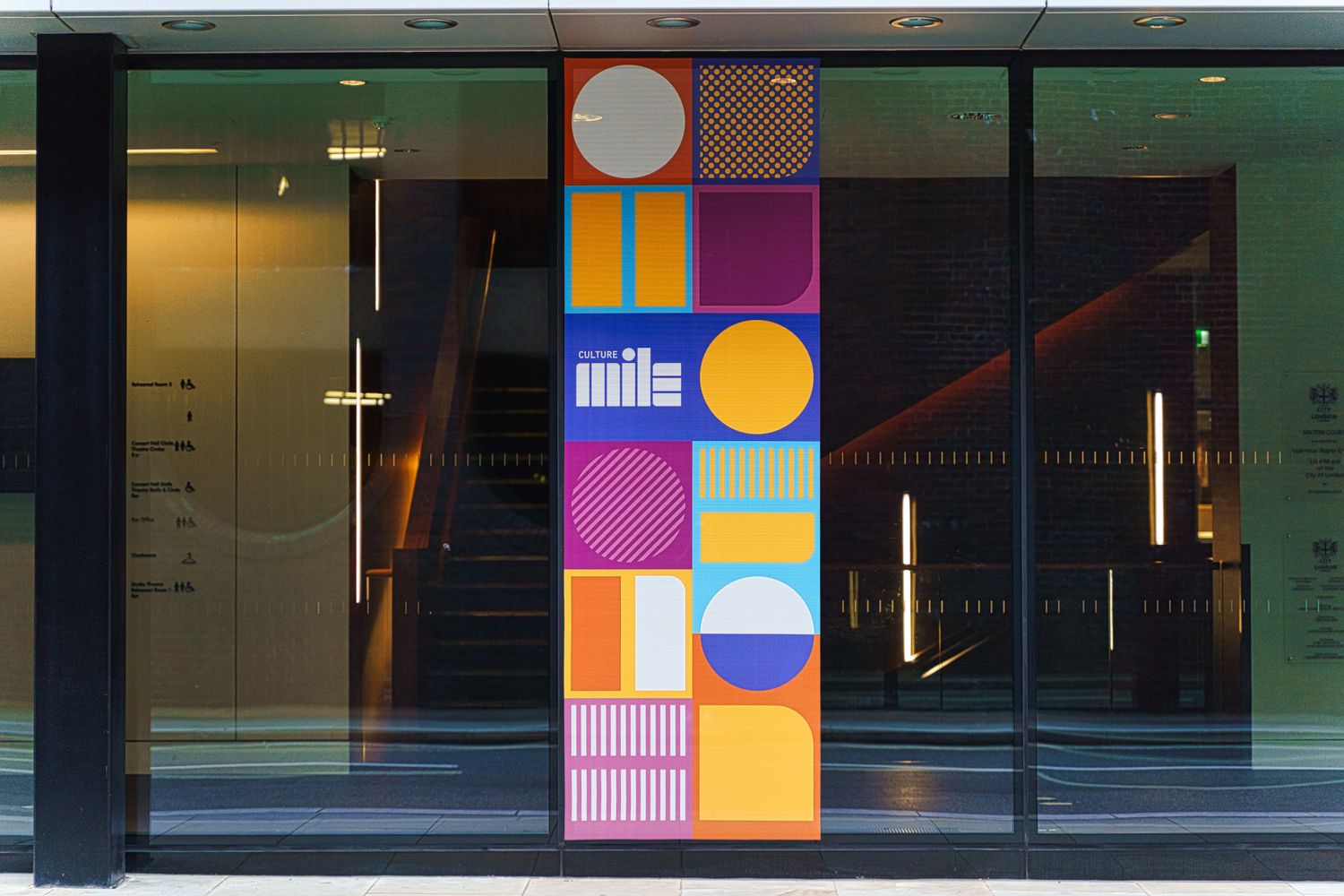 A striking window banner for the Guildhall School of Music & Drama, emblazoned with Culture Mile's unique colourway and abstract design.